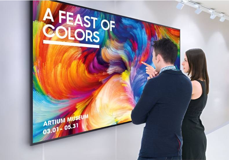 Personas frente a la pantalla Samsung QM85RB exponiendo el color UHD 